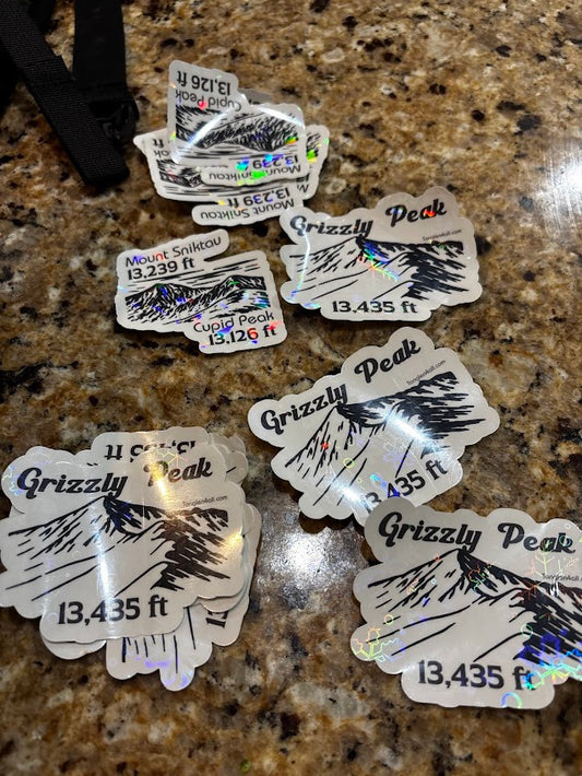 Multiple 'Grizzly Peak' stickers on a granite countertop