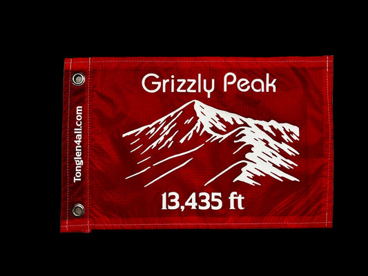 Red flag with white text Grizzly Peak and elevation and mountain logo 