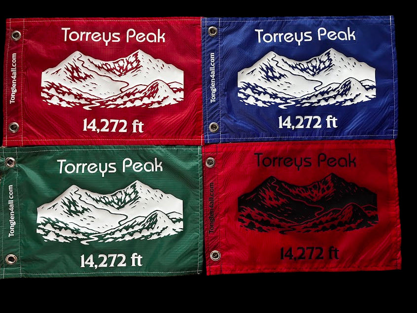 Four fabric patches of Torreys Peak with mountain illustration and height on a textured surface.