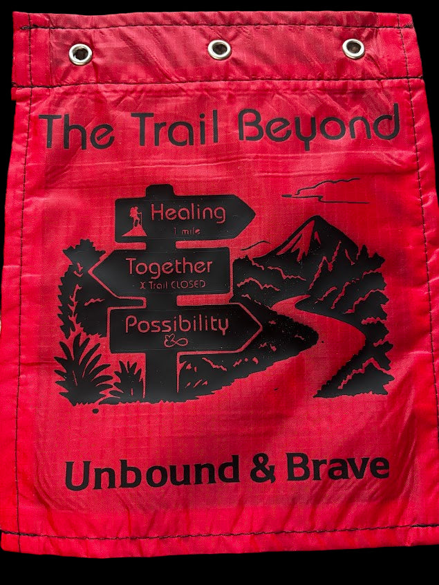 Red bag with black text and graphics on a textured surface